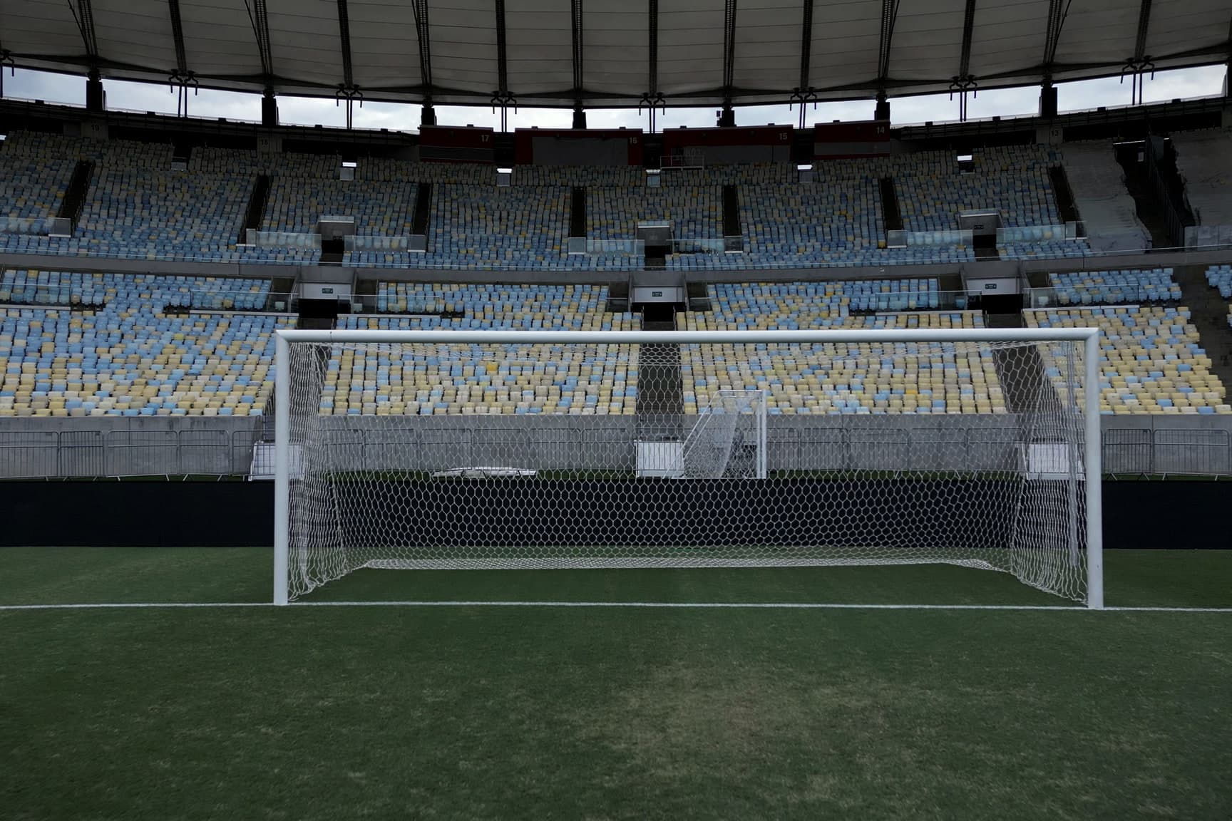 Um gol do Maracanã visto de frente, da linha da grande área, com a rede armada e as arquibancadas vazias atrás.